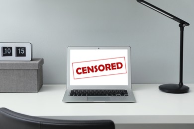 Laptop with censorship sign on white table