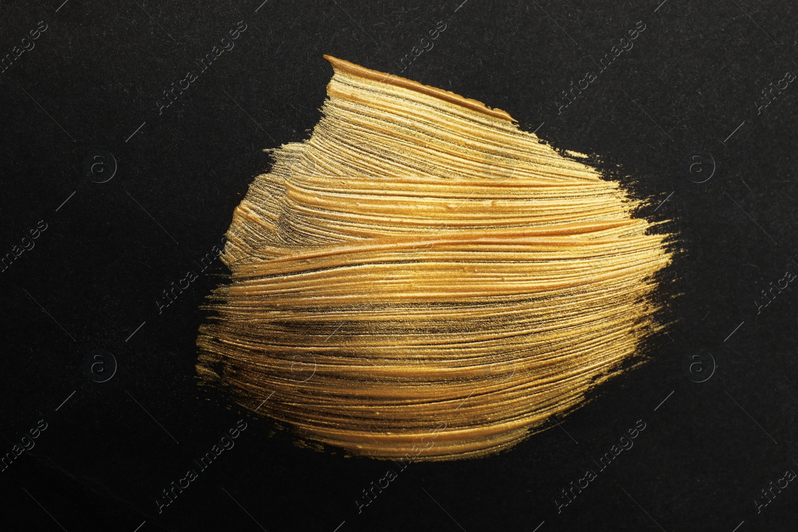 Photo of Golden paint brush strokes on black background