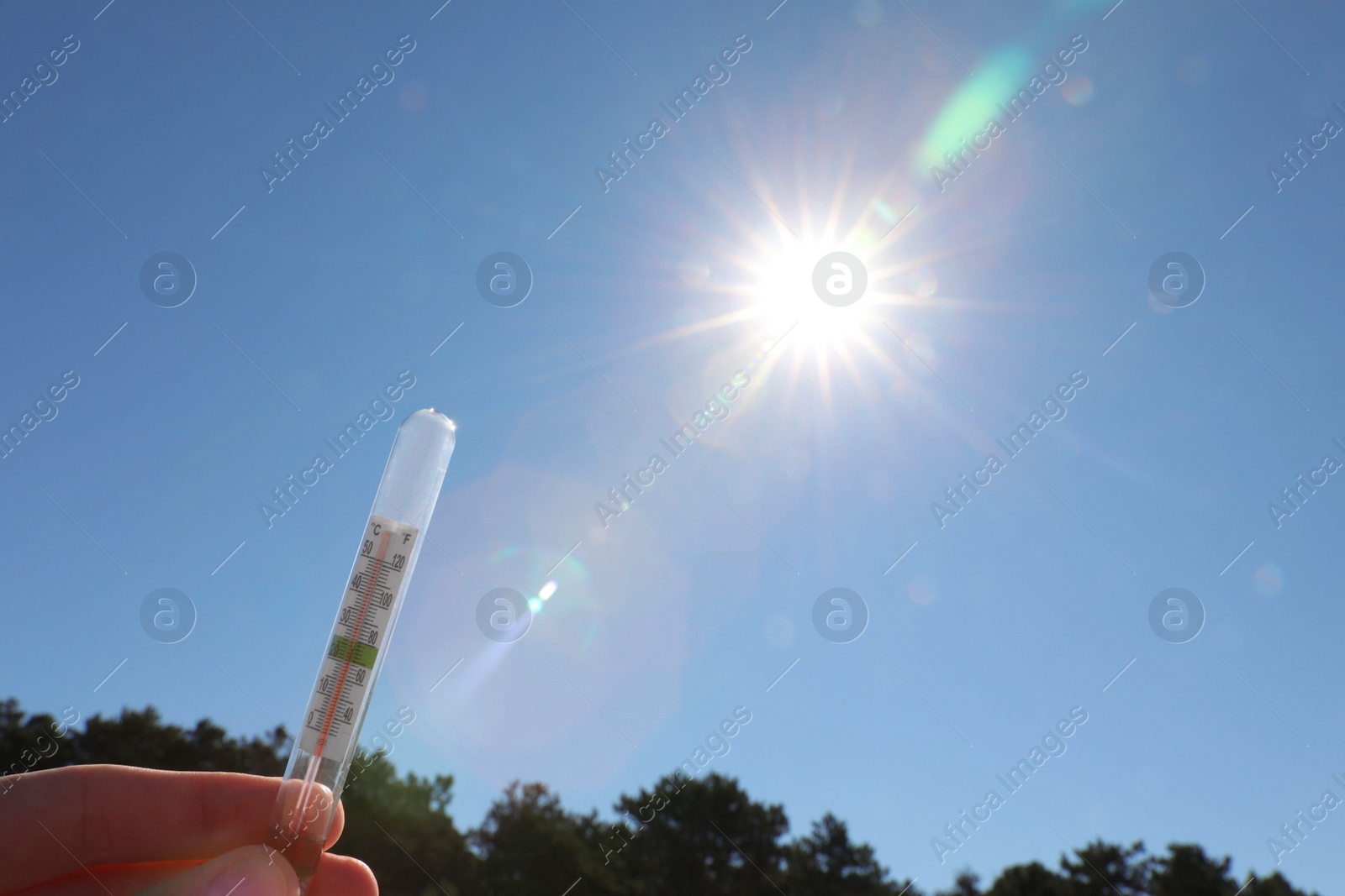 Photo of Woman holding weather thermometer against blue sky, space for text