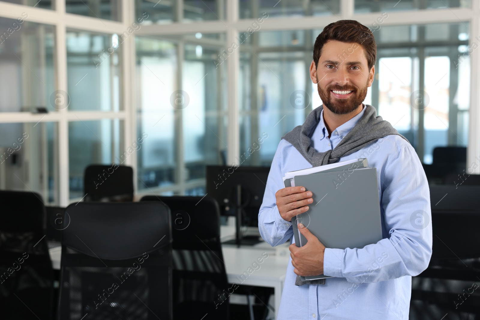 Photo of Happy man with folders in office, space for text