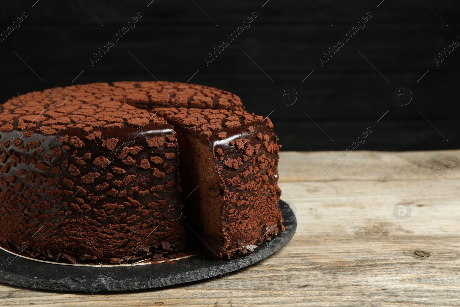 Photo of Delicious chocolate truffle cake on wooden table, space for text