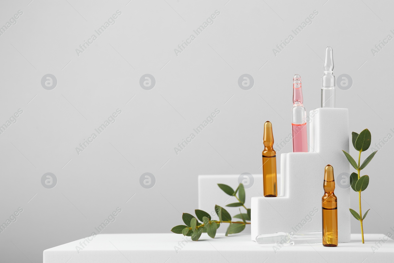 Photo of Stylish presentation of different skincare ampoules on white background. Space for text