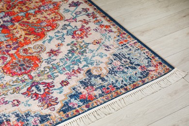 Photo of Soft carpet with pattern on white laminated floor indoors