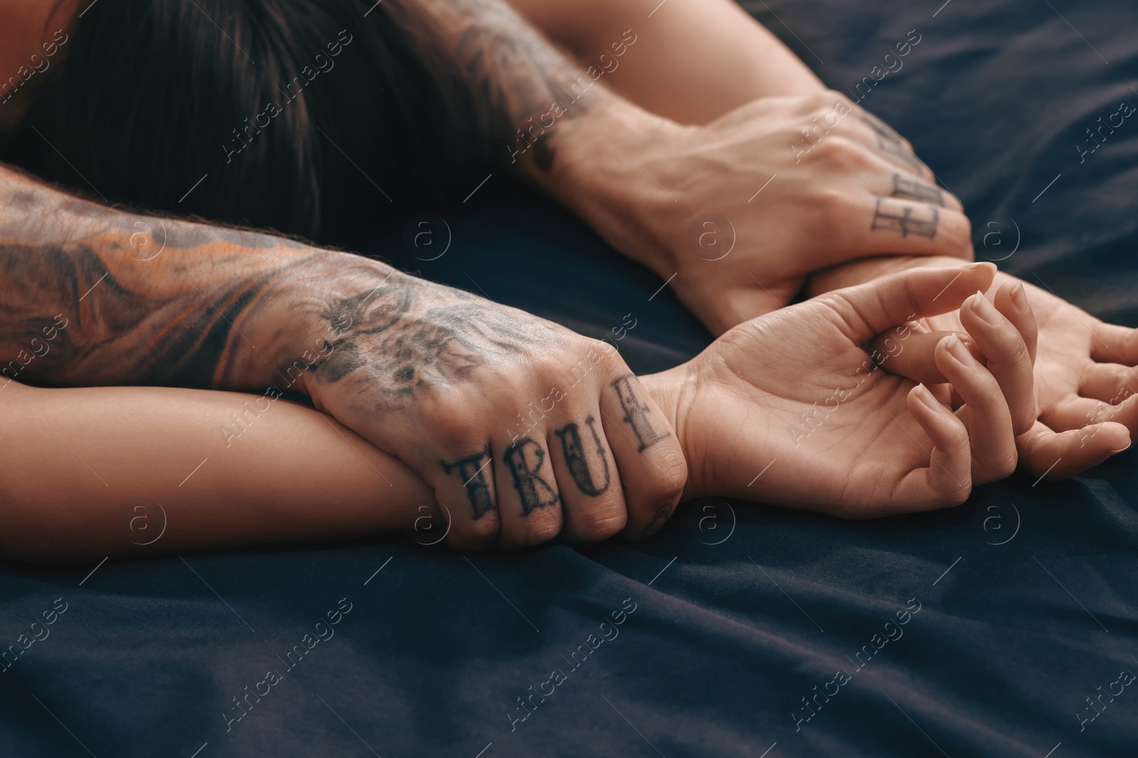 Photo of Passionate couple having sex on bed, closeup of hands