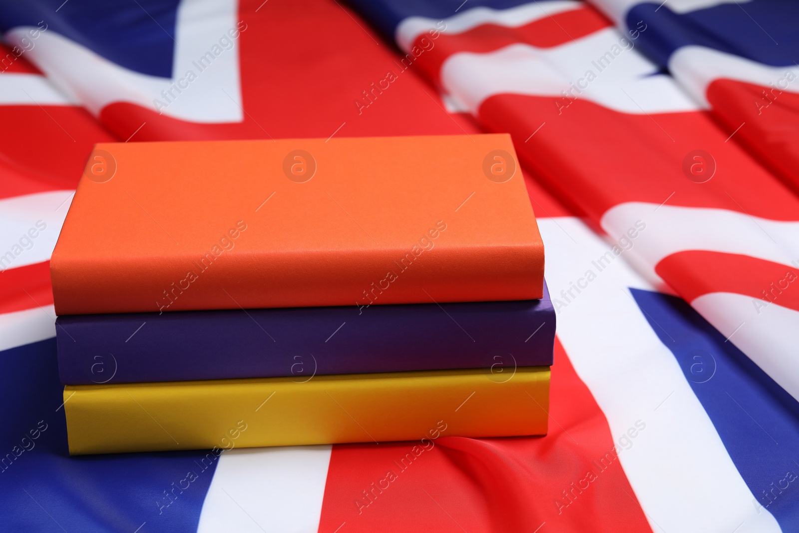 Photo of Learning foreign language. Different books on flag of United Kingdom