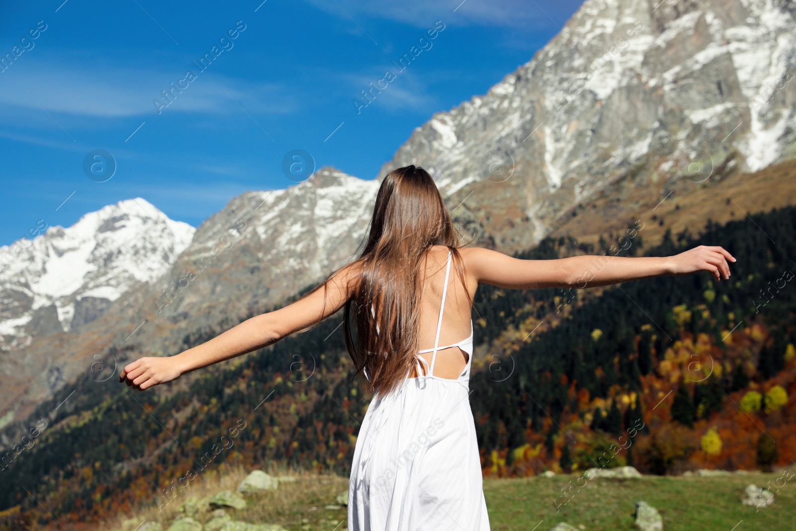 Photo of Young woman walking in beautiful mountains on sunny day