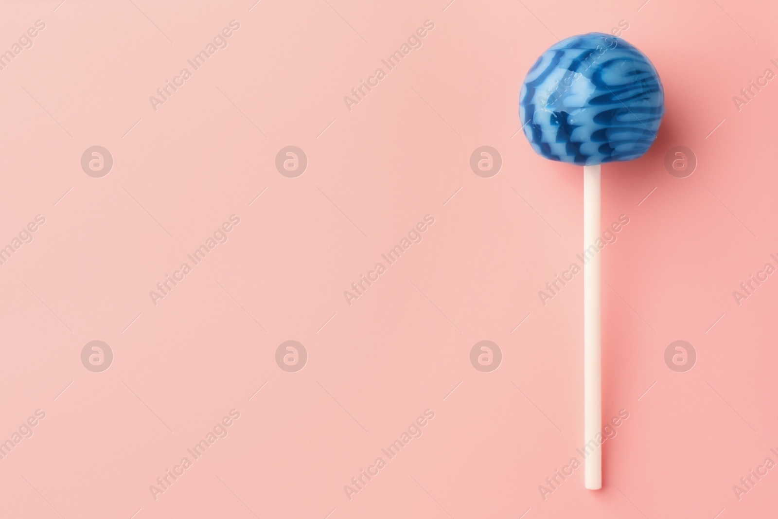 Photo of One tasty lollipop on pink background, top view. Space for text