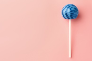 One tasty lollipop on pink background, top view. Space for text