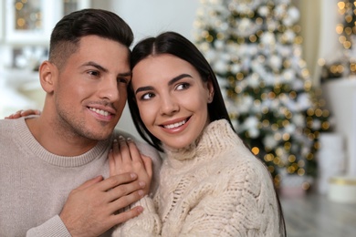 Happy couple in festively decorated room. Christmas celebration