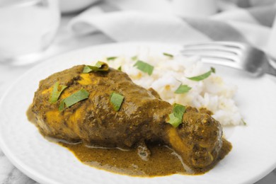 Delicious rice and chicken with curry sauce served on plate, closeup