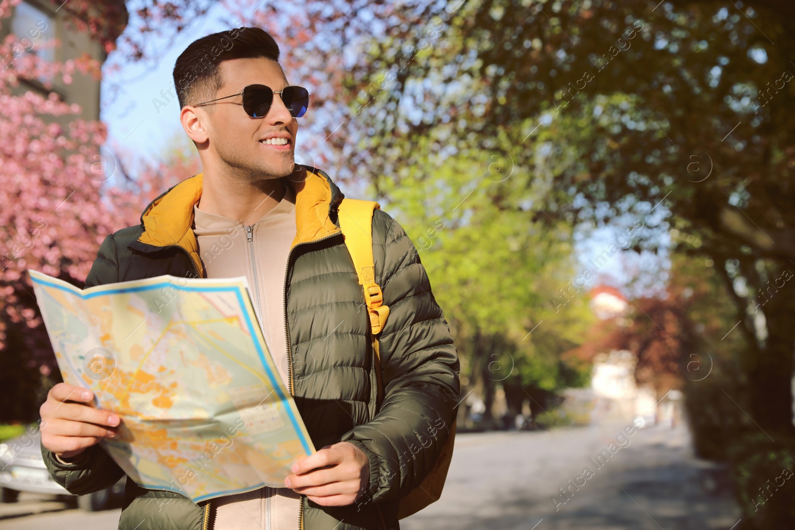 Photo of Happy male tourist with map on city street