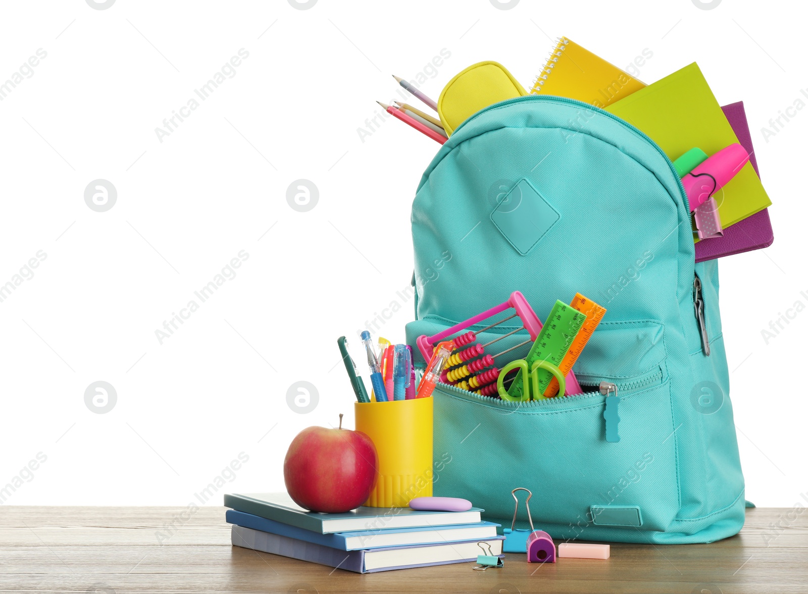 Photo of Stylish backpack with different school stationary and apple on wooden table against white background