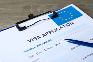 Photo of Visa application form for immigration to European Union and pen on table, closeup