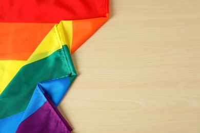 Rainbow gay flag on wooden background, top view with space for text. LGBT concept