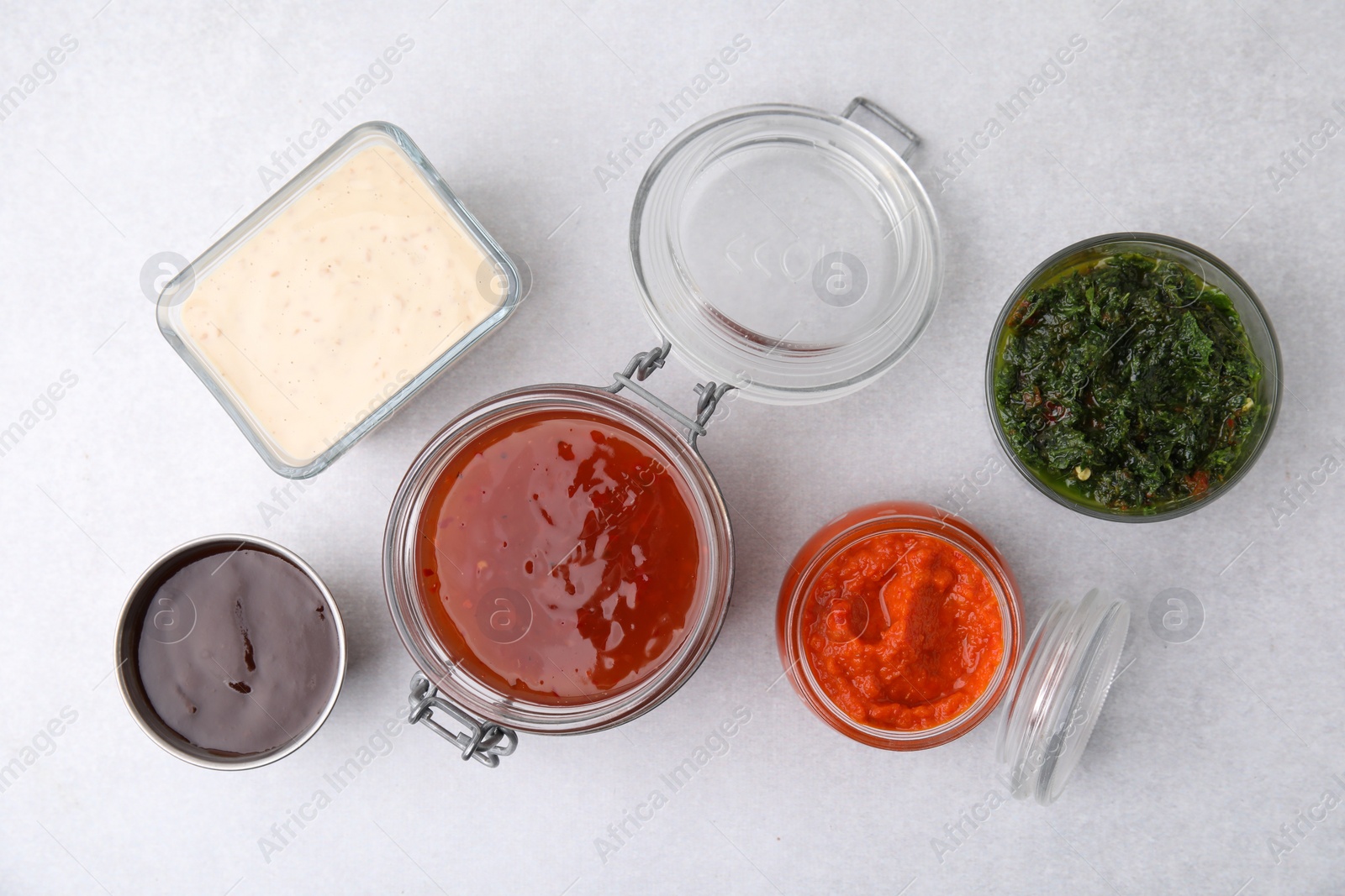 Photo of Different marinades on light table, flat lay