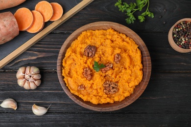 Flat lay composition with mashed sweet potatoes on wooden background