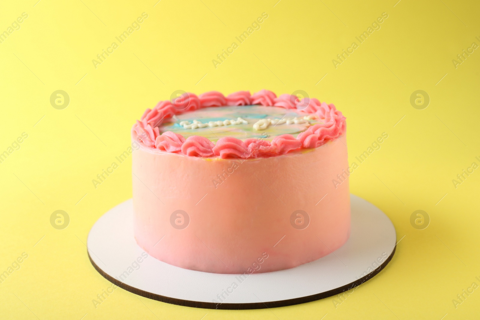 Photo of Cute bento cake with tasty cream on yellow background