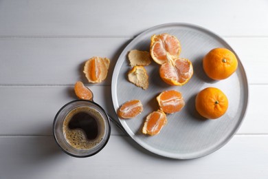 Fresh ripe tangerines and cup of coffee on white wooden table, flat lay