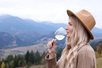 Young woman drinking wine in peaceful mountains