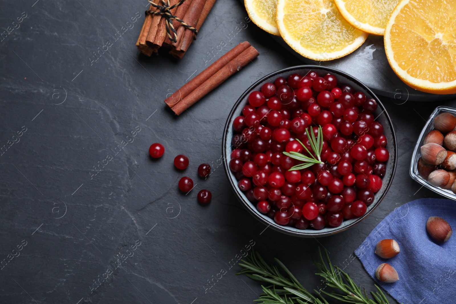 Photo of Flat lay composition with fresh ripe cranberries on dark grey table. Space for text