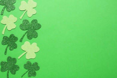 Photo of Decorative clover leaves on green background, flat lay with space for text. St. Patrick's Day celebration