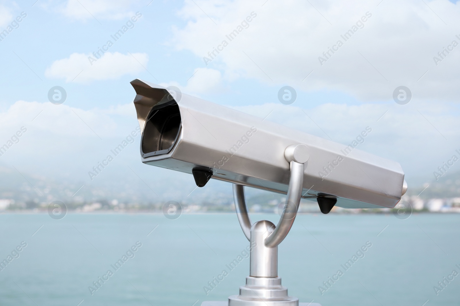 Photo of Metal tower viewer installed near sea. Mounted binoculars