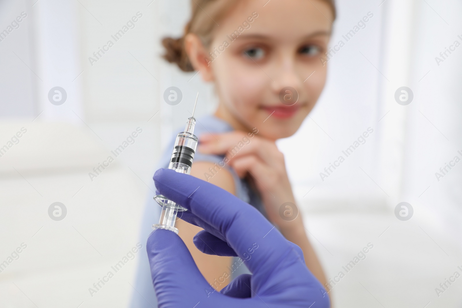 Photo of Doctor giving injection to little girl in hospital, focus on hand. Immunization concept