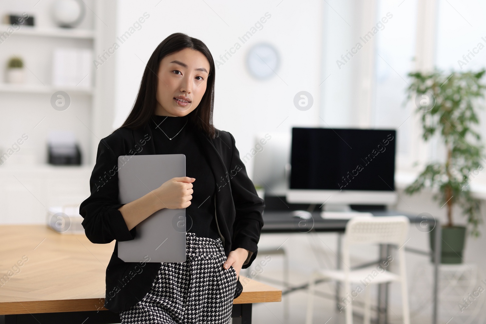 Photo of Portrait of beautiful businesswoman with laptop in office. Space for text