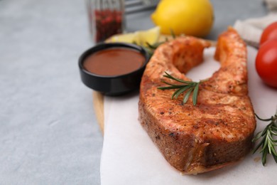 Photo of Fresh marinade and cooked fish on grey table, closeup. Space for text