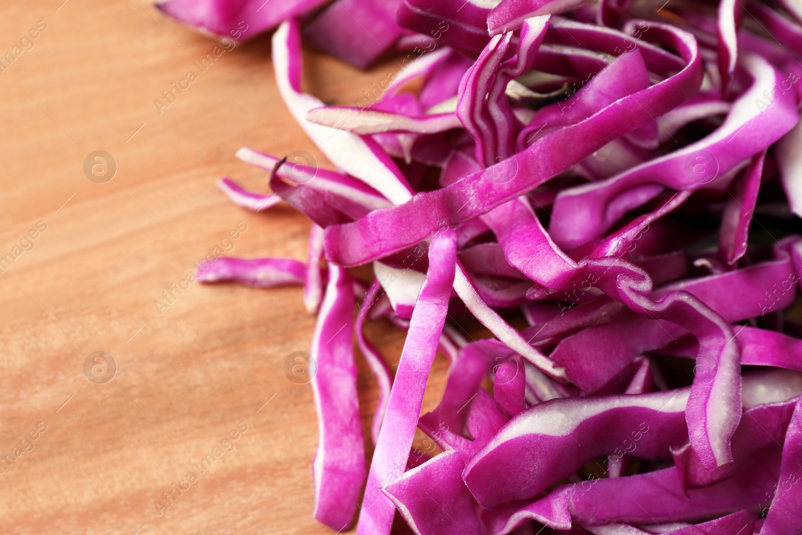 Photo of Sliced fresh red cabbage on wooden table, closeup