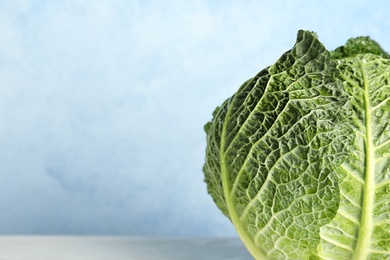 Photo of Savoy cabbage on table against color background, closeup. Space for text