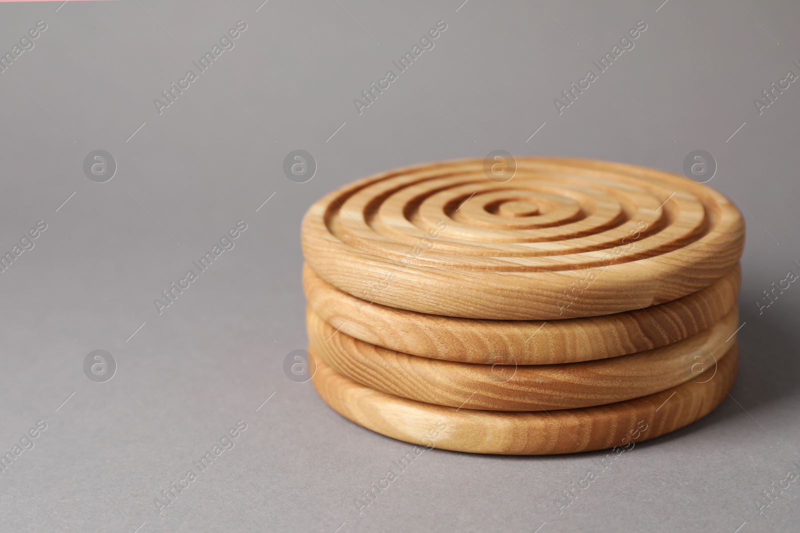 Photo of Stylish wooden cup coasters on light grey background, space for text