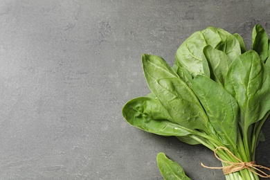 Photo of Bunch of fresh green healthy spinach on grey table, top view. Space for text