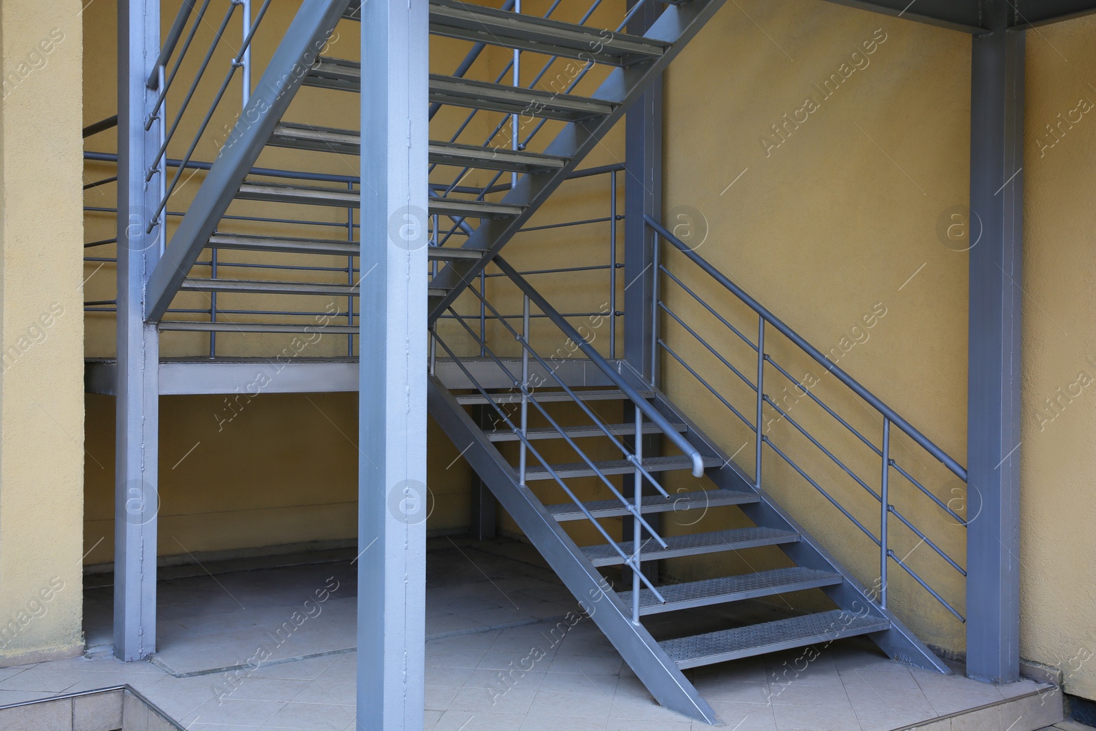 Photo of Metal fire escape ladder near building outdoors, low angle view