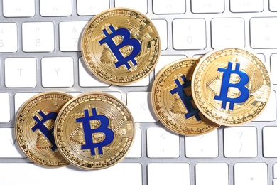 Golden bitcoins on computer keyboard, flat lay. Digital currency