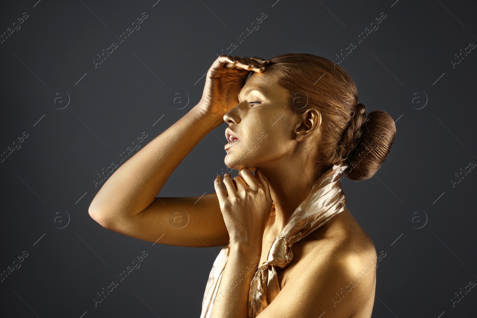 Photo of Portrait of beautiful lady with gold paint on skin against grey background