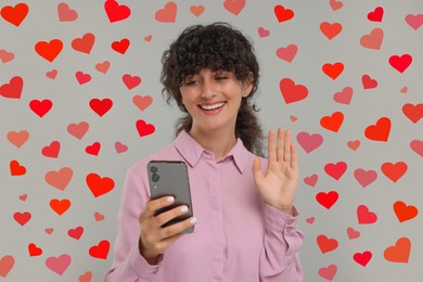 Image of Long distance love. Woman video chatting with sweetheart via smartphone on grey background. Hearts around her