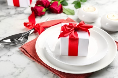 Photo of Beautiful table setting for Valentine's Day dinner with gift box on white marble background