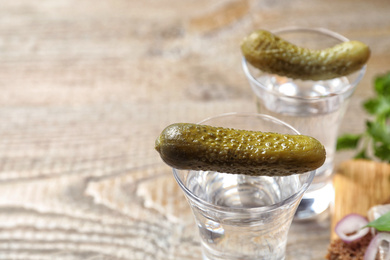 Photo of Cold Russian vodka with pickles on table, closeup