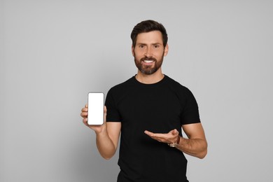 Photo of Happy man with smartphone on light background