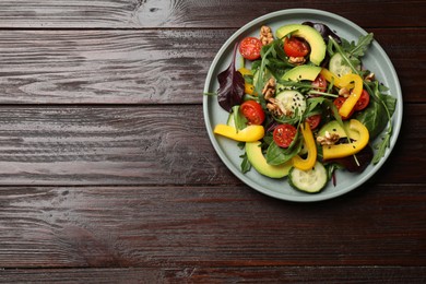 Balanced diet and vegetarian foods. Plate with different delicious products on wooden table, top view. Space for text