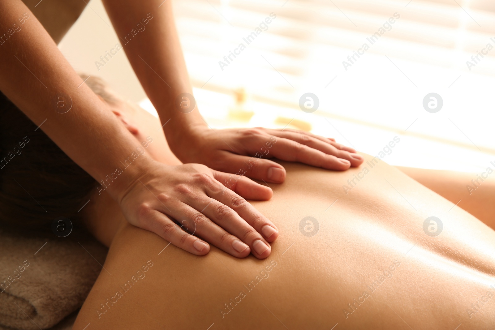 Photo of Young woman receiving back massage in spa salon, closeup