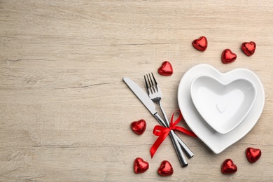 Beautiful table setting on white wooden background, flat lay with space for text. Valentine's Day dinner