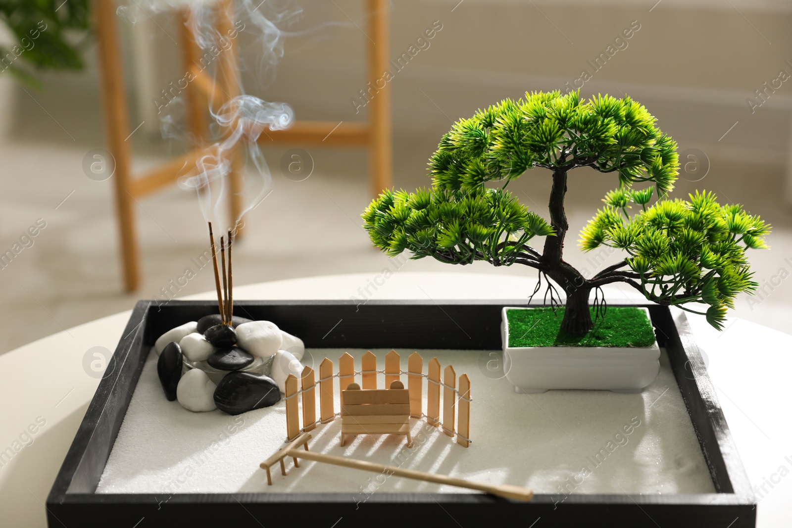 Photo of Beautiful miniature zen garden with incense sticks on table indoors