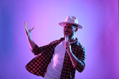 Emotional man with microphone singing in neon lights