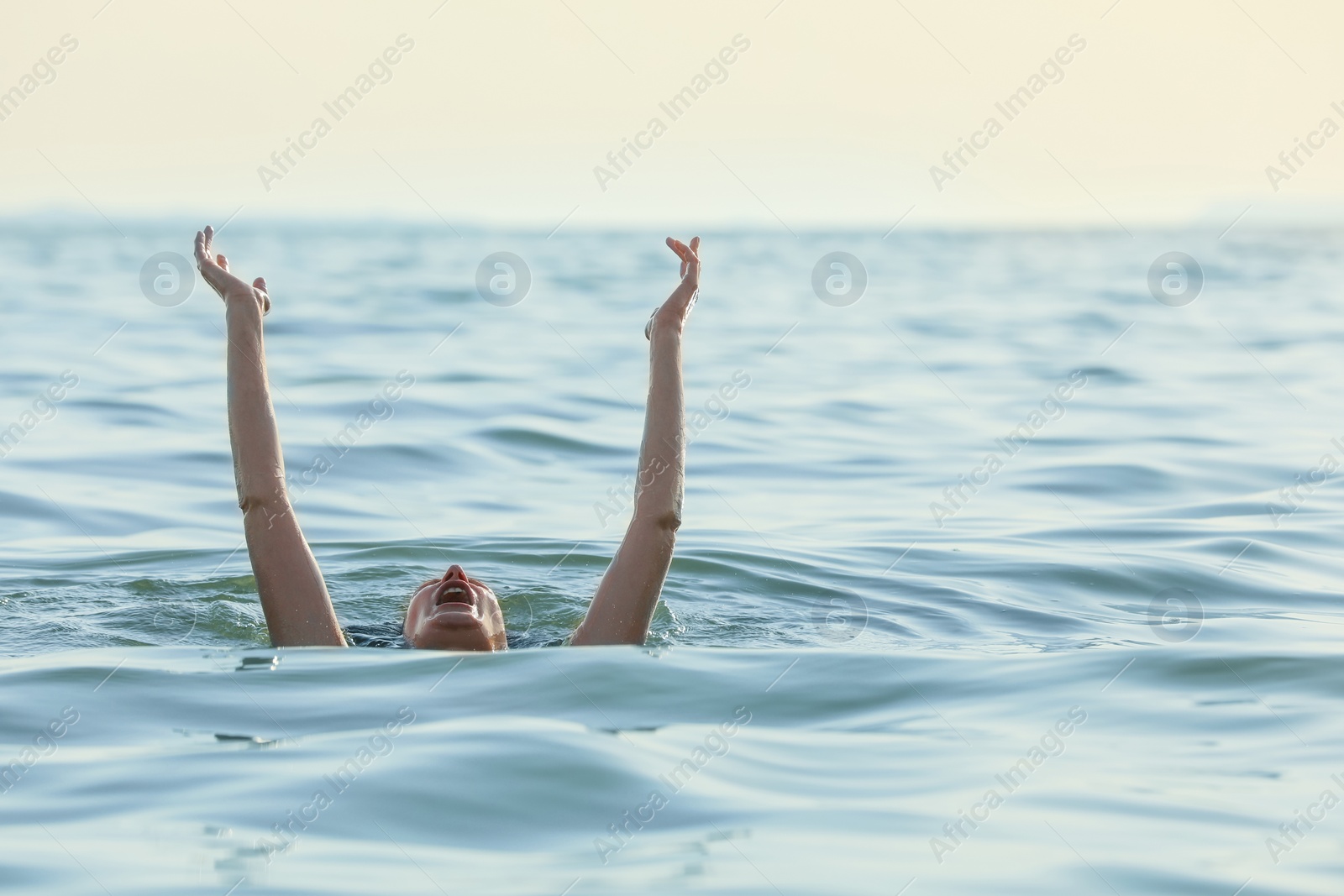 Photo of Drowning woman reaching for help in sea