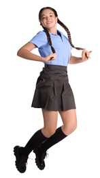 Photo of Teenage girl in school uniform jumping on white background