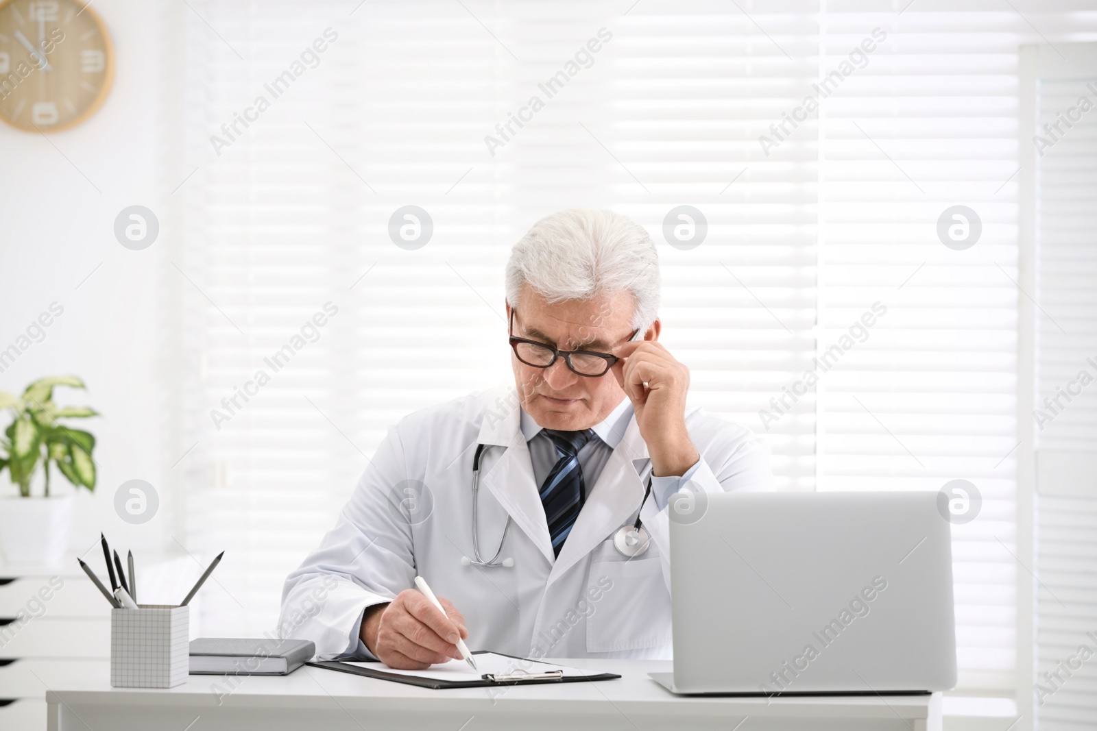 Photo of Senior doctor working at table in office