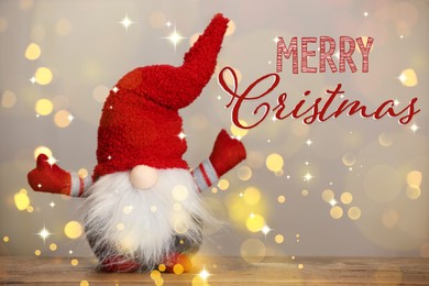 Image of Merry Christmas! Cute Christmas gnome on wooden table against blurred festive lights, bokeh effect