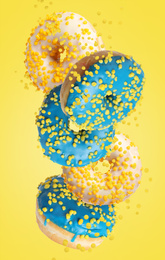 Image of Set of falling delicious donuts on yellow background